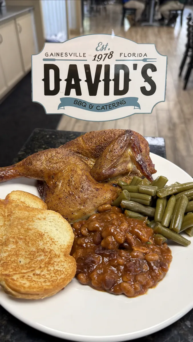 Half a smoked chicken with baked beans, green beans, and garlic toast, under the David's BBQ and Catering plaque