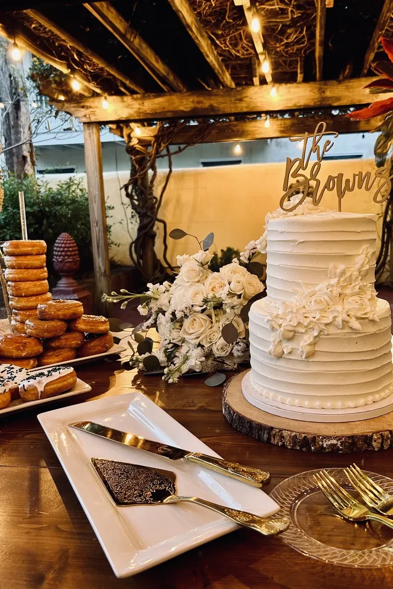 Wedding cake beside a stacked donut tower with gold servers