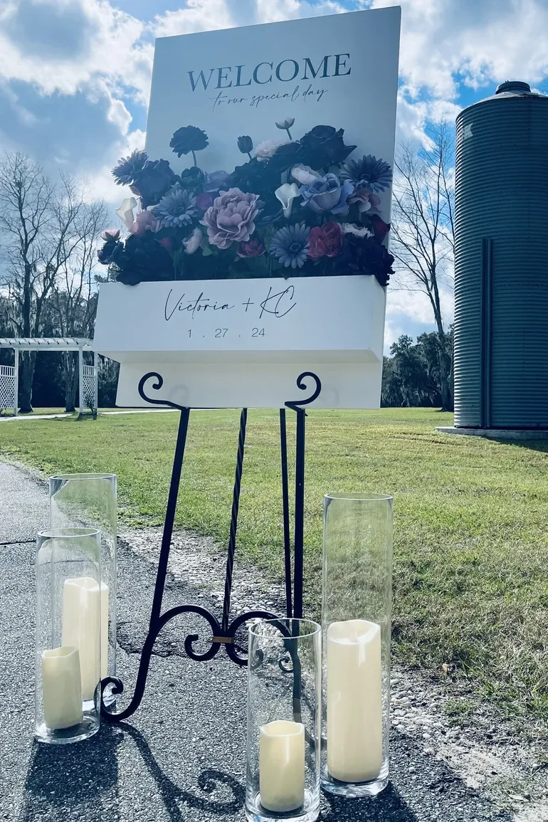 Outdoor welcome sign with pillar candles for Victoria and KJ
