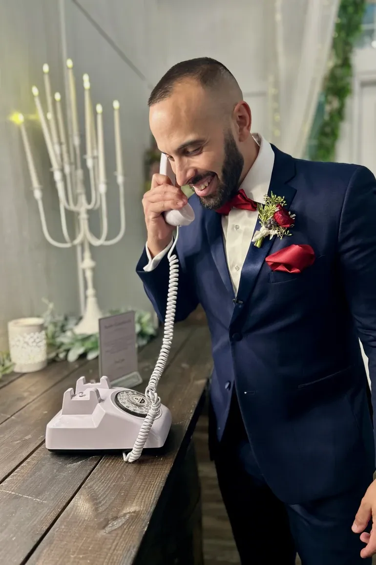 Groom leaving a message on a vintage audio guest book phone