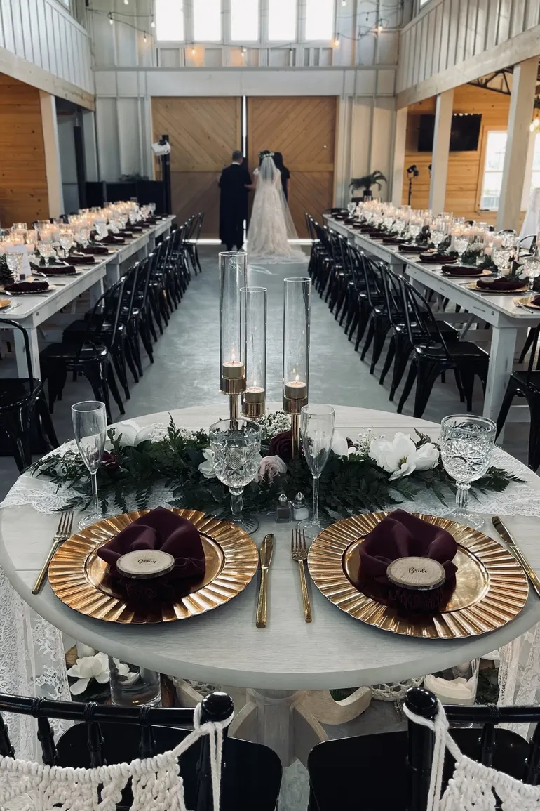 Couple at the doors of an industrial hall lined with candlelit tables
