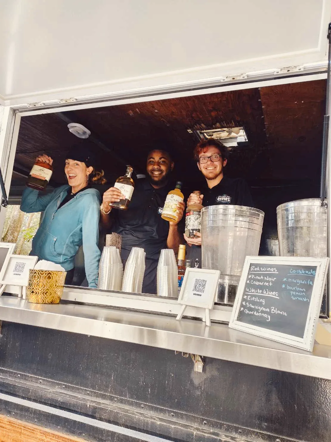Staff smiling from the window of the catering food truck