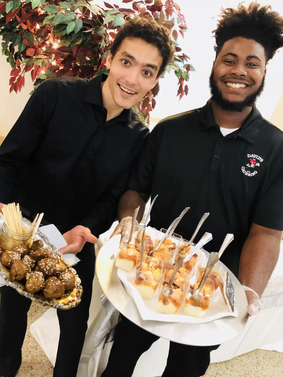 Two staff holding platters of skewered appetizers