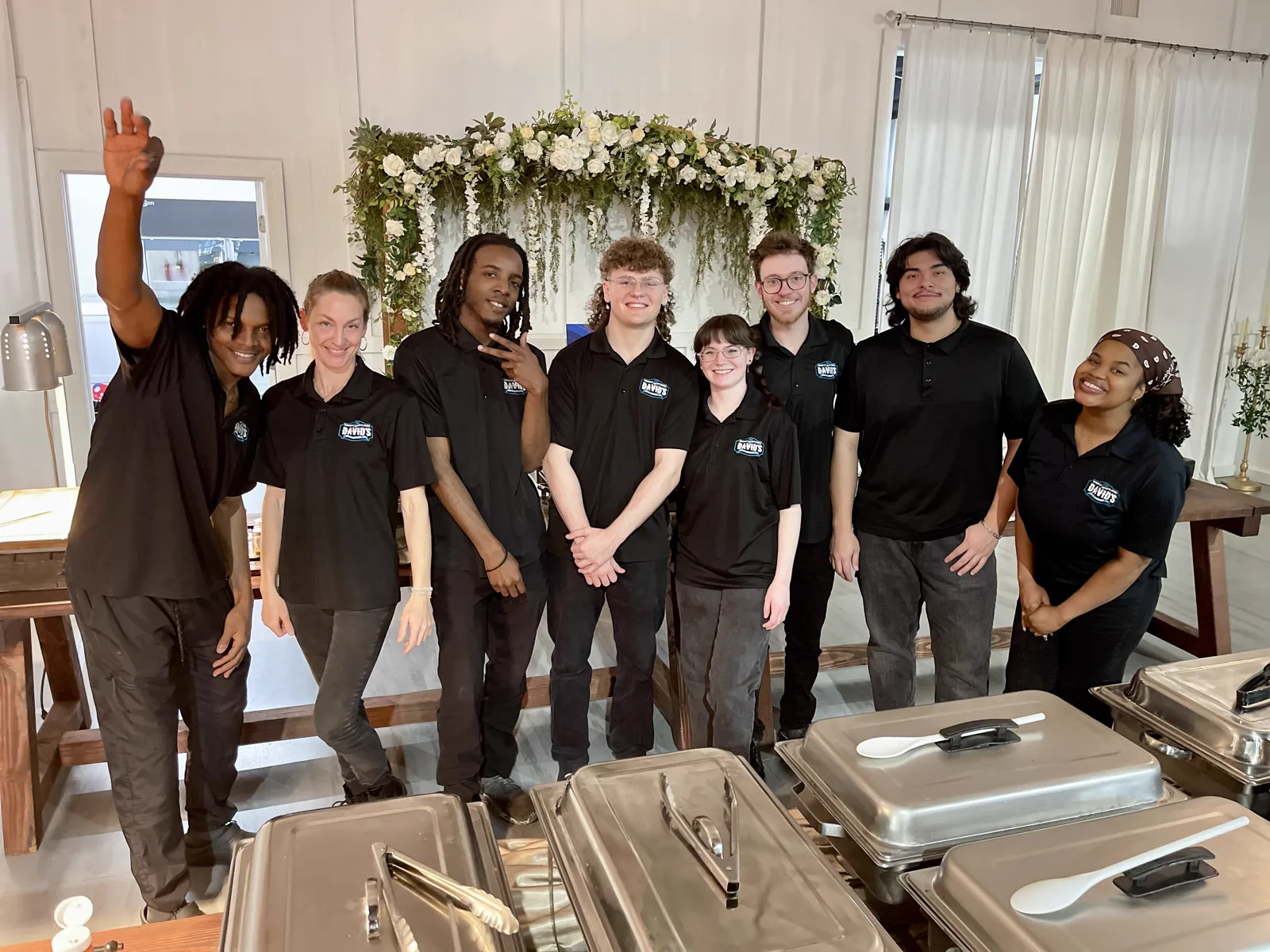 The catering team lined up behind a row of chafing dishes