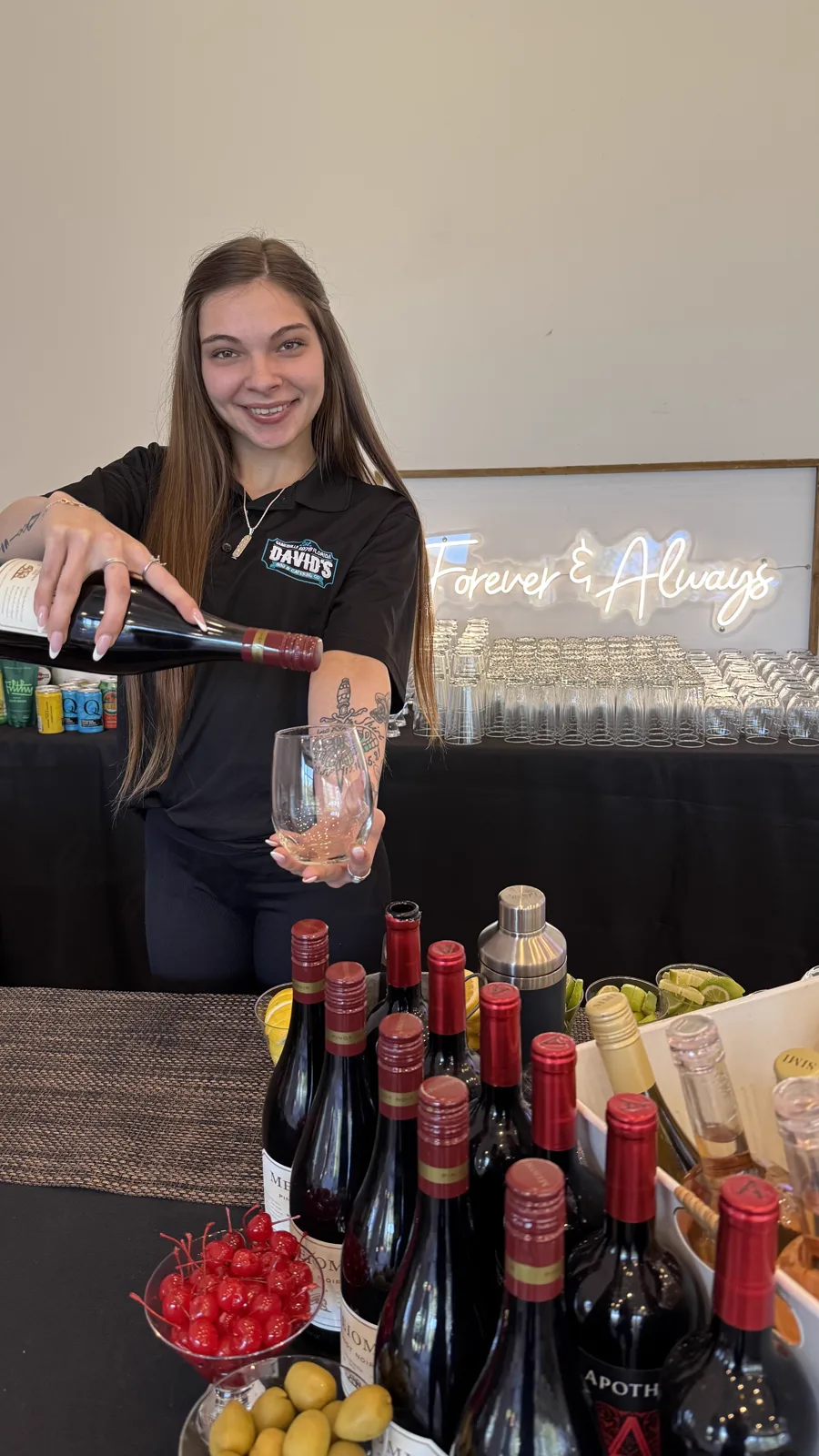 A bartender pouring wine at a fully stocked bar
