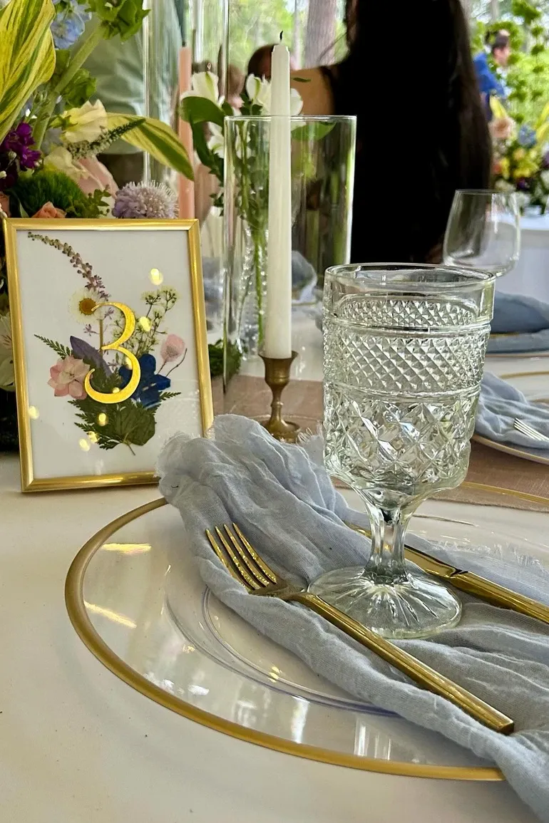 Framed pressed-flower table number three with candles and cut crystal