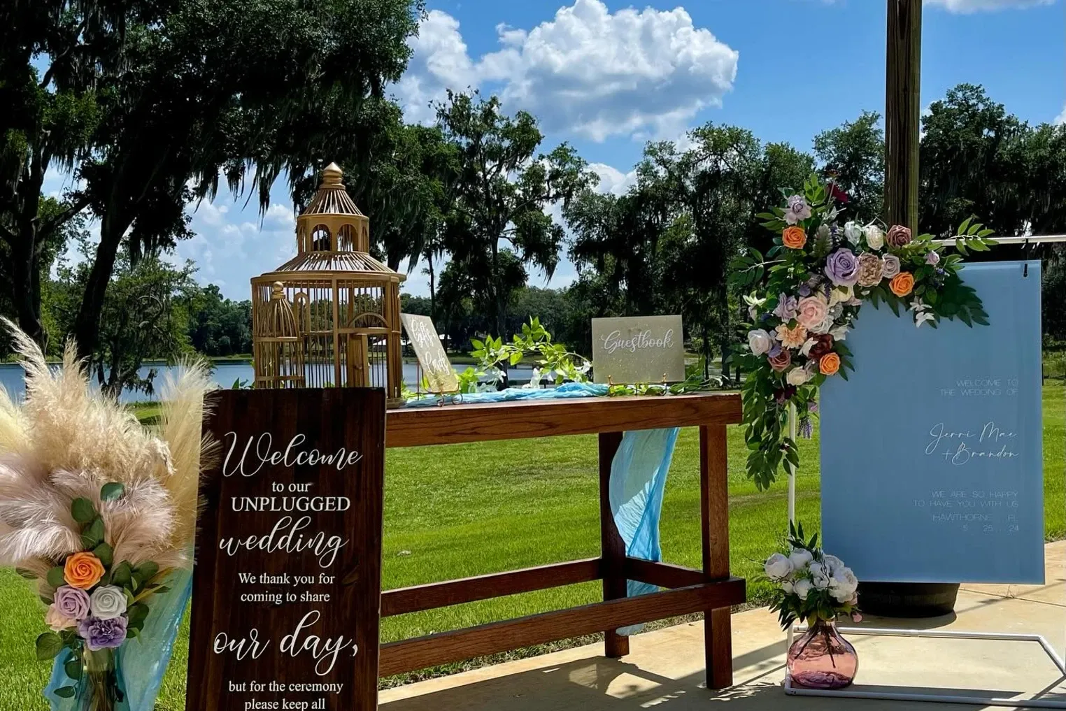 Welcome table with florals and a guest book overlooking the lawn