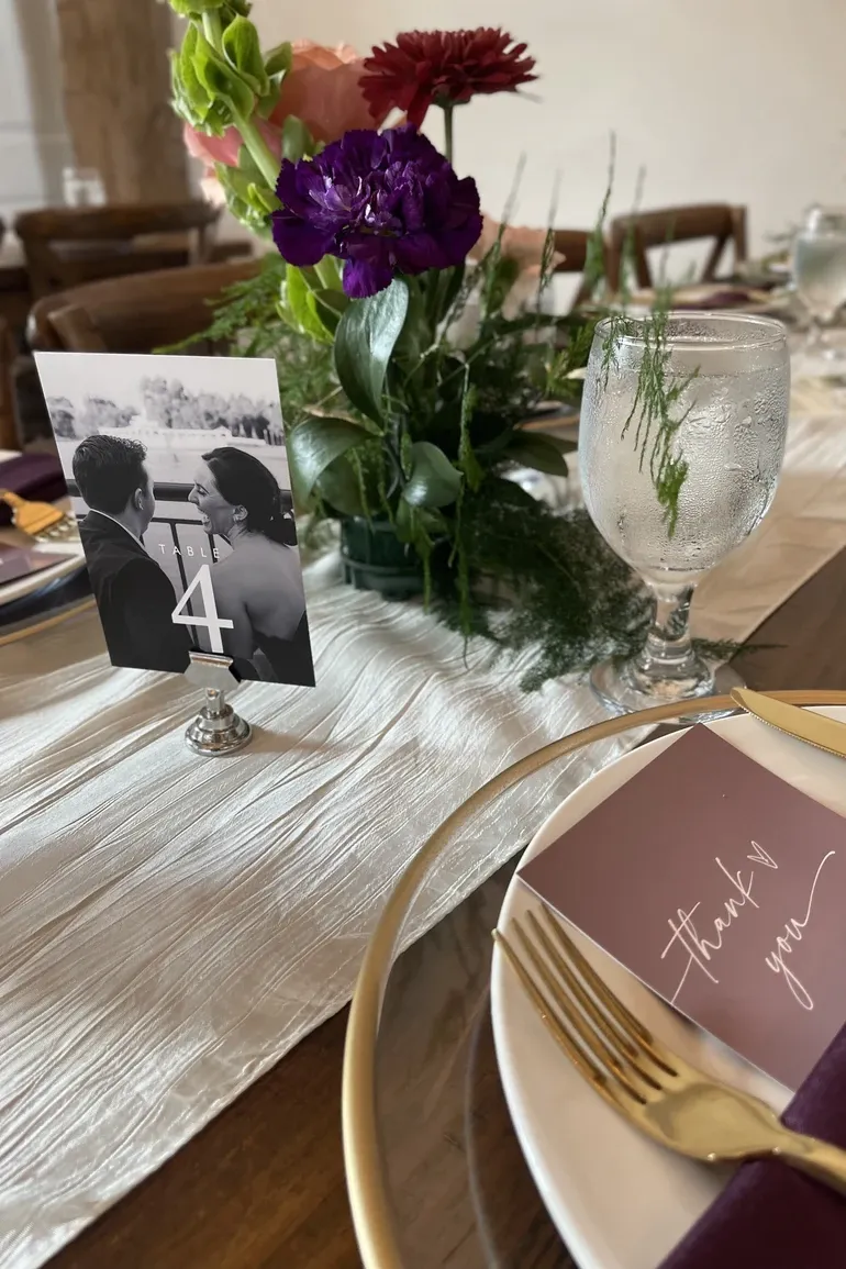Table number four with a photo of the couple and purple flowers