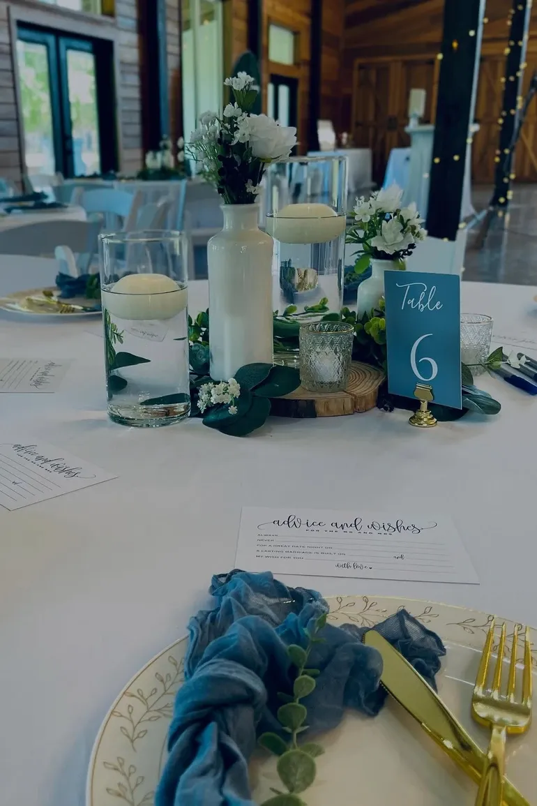 Floating candles and white florals beside a table six card