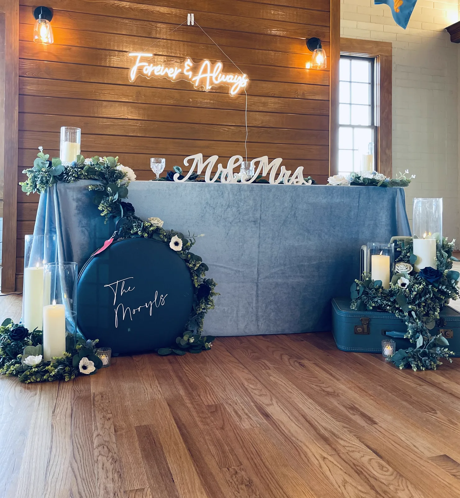 A sweetheart table with a Forever and Always neon sign and greenery