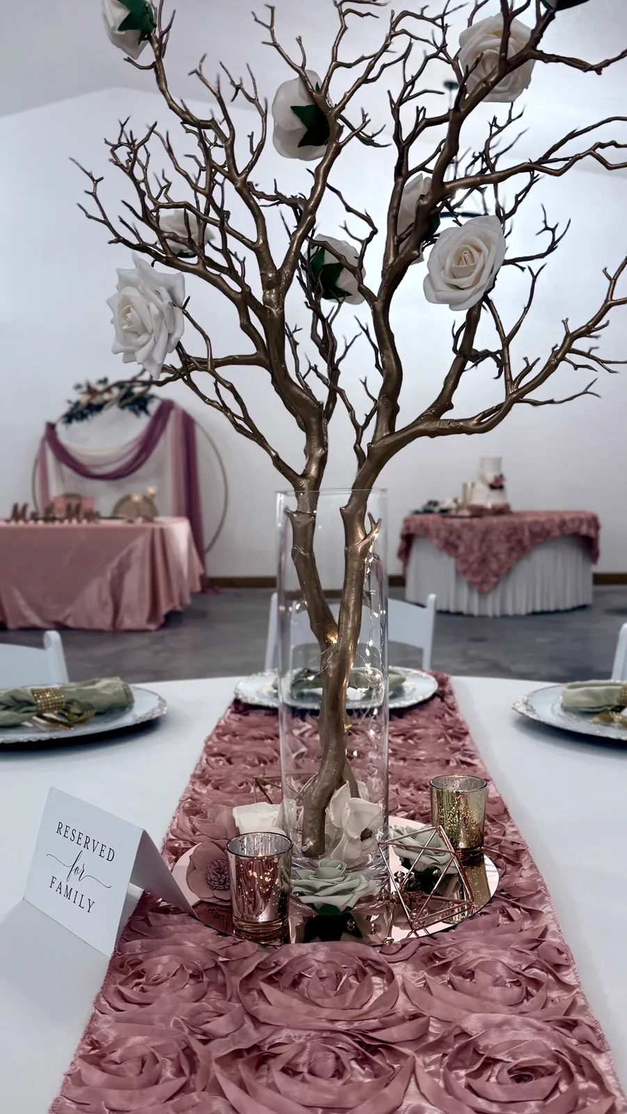 A manzanita branch centerpiece above a mauve table runner