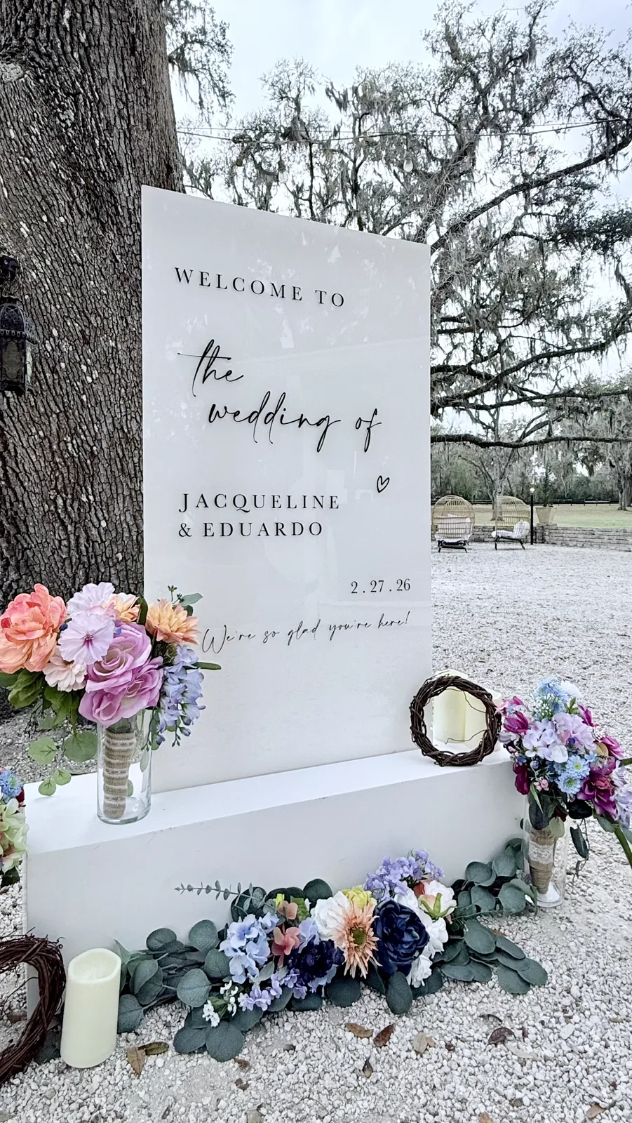 A marble welcome sign surrounded by soft florals