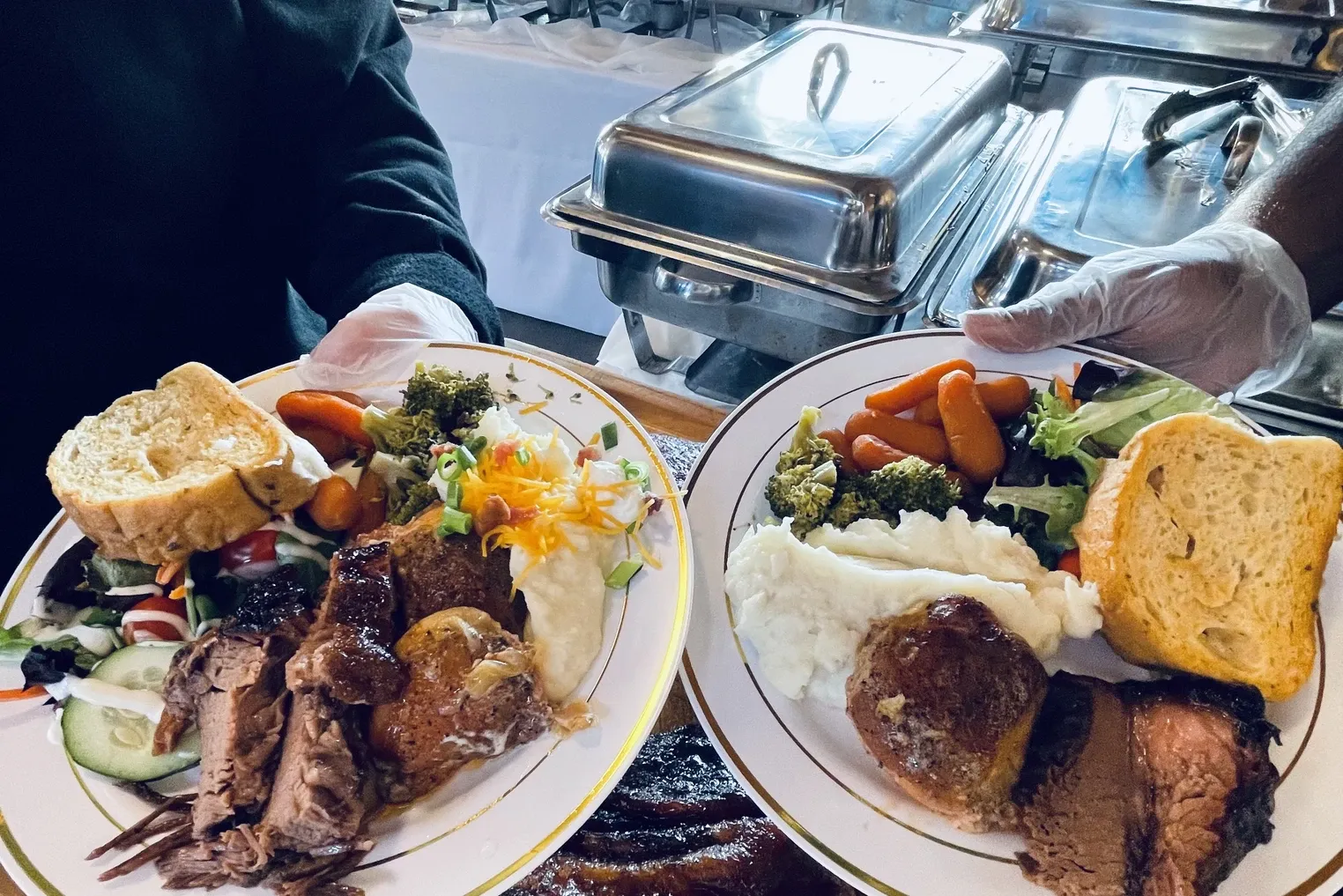 Buffet plates with mashed potatoes, vegetables, glazed meatball, and bread