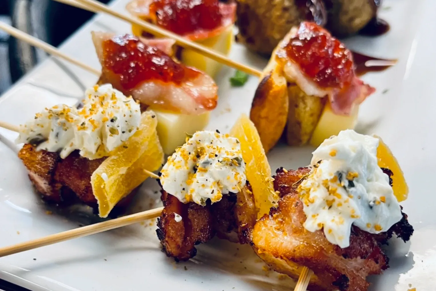 Passed appetizer skewers topped with whipped cheese and pepper jelly