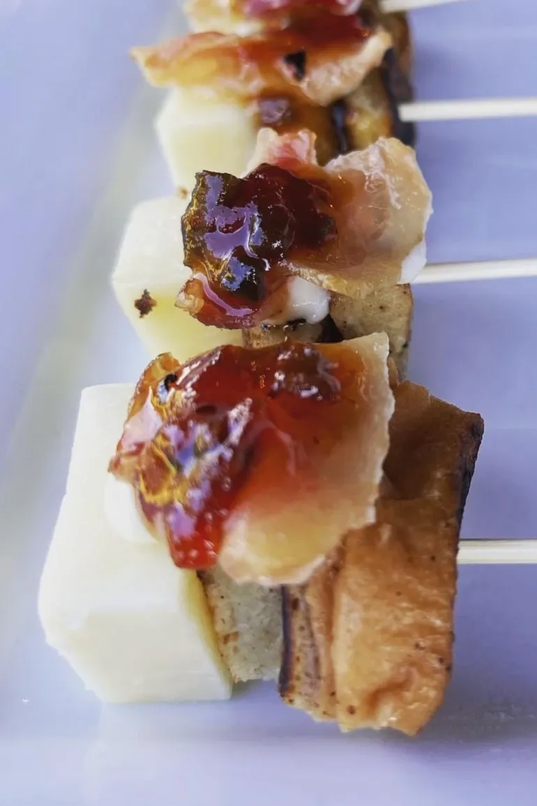 Cheese bite topped with bacon and pepper jelly
