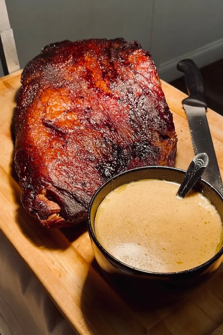 Smoked prime rib with a bowl of au jus.