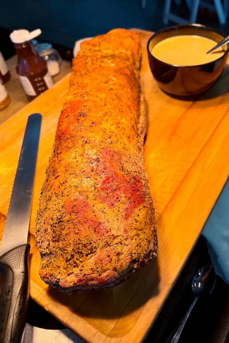 A whole smoked loin resting on a cutting board.