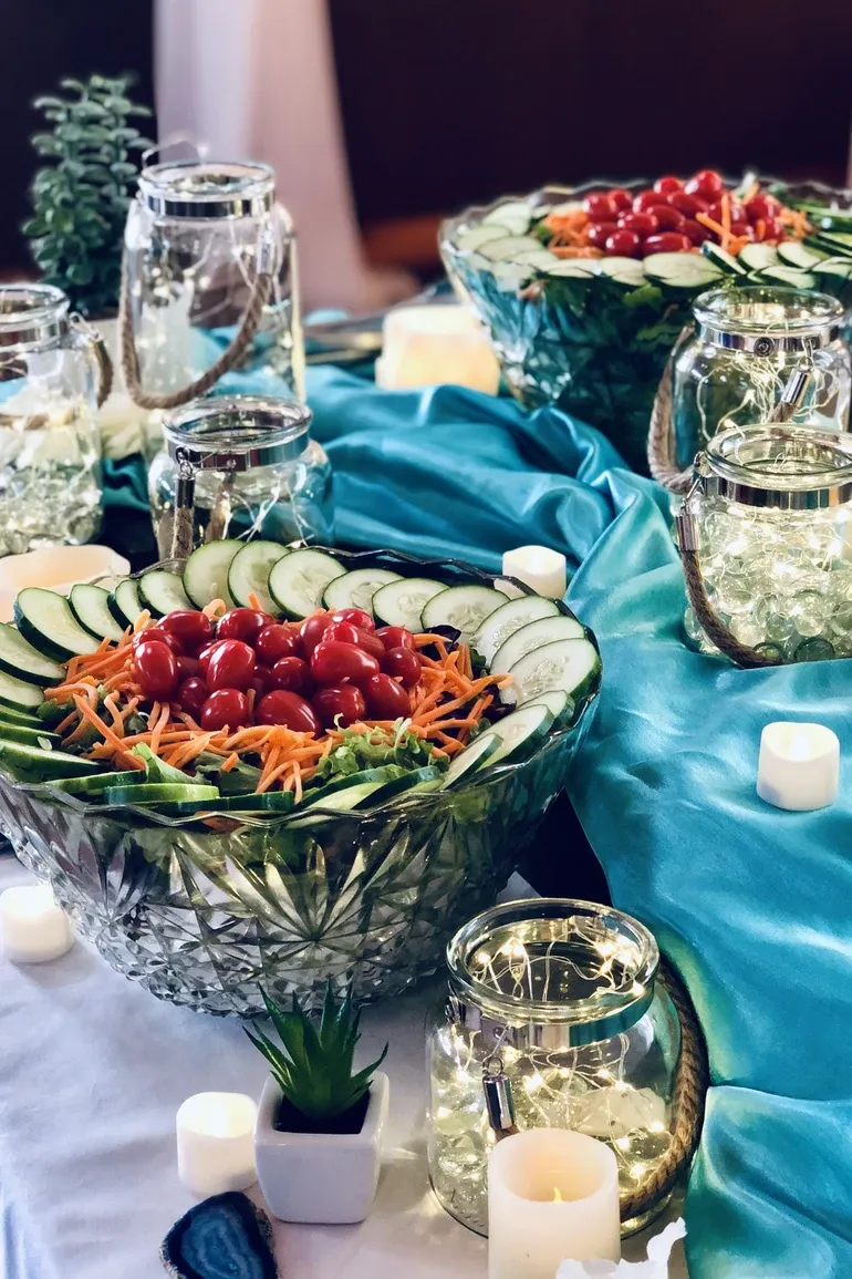 Crudite bowls with cucumber, carrots, and tomatoes on teal satin