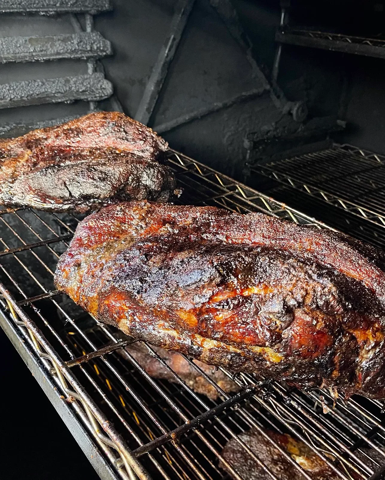 Racks of pork resting on the smoker grates