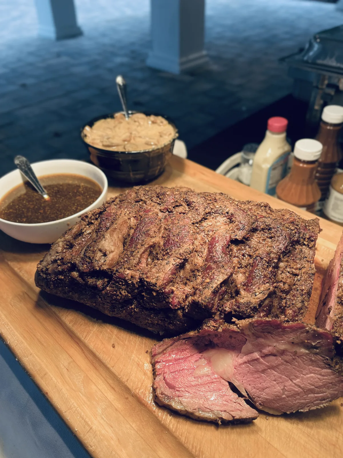 Sliced prime rib fanned across a wooden carving board