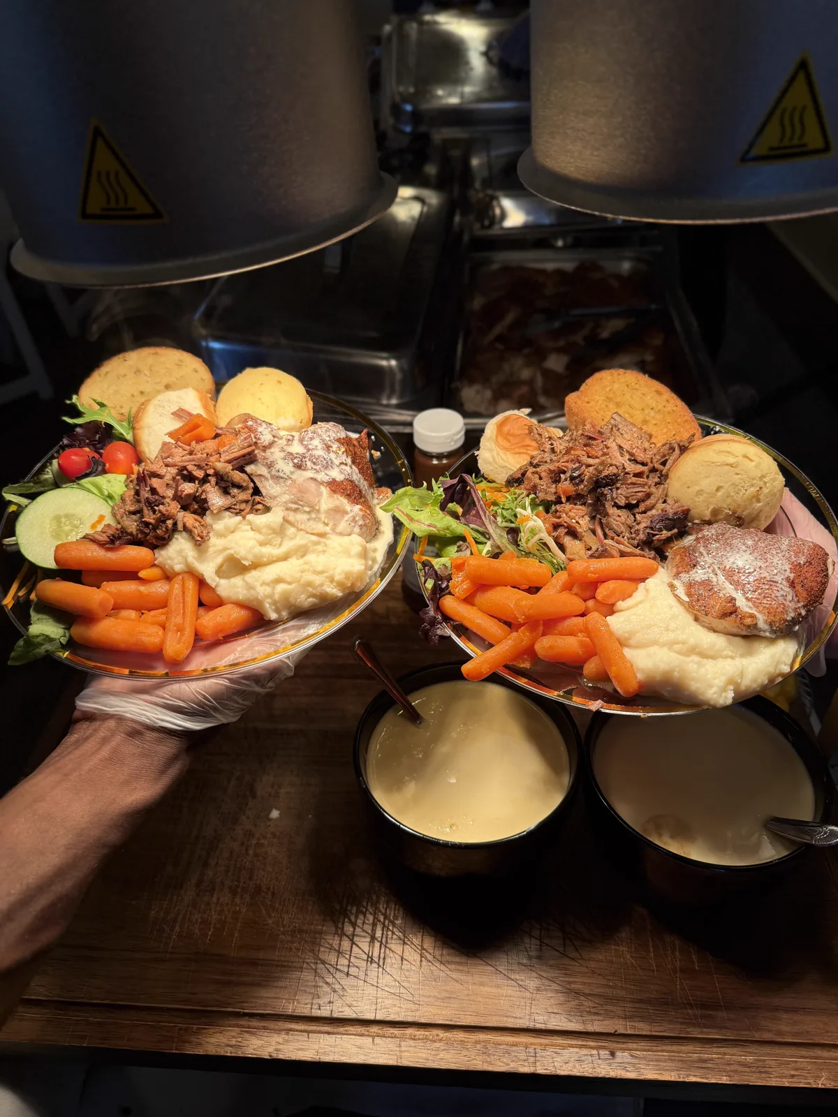Plated carrots, rolls and dipping sauces arranged on a wooden board