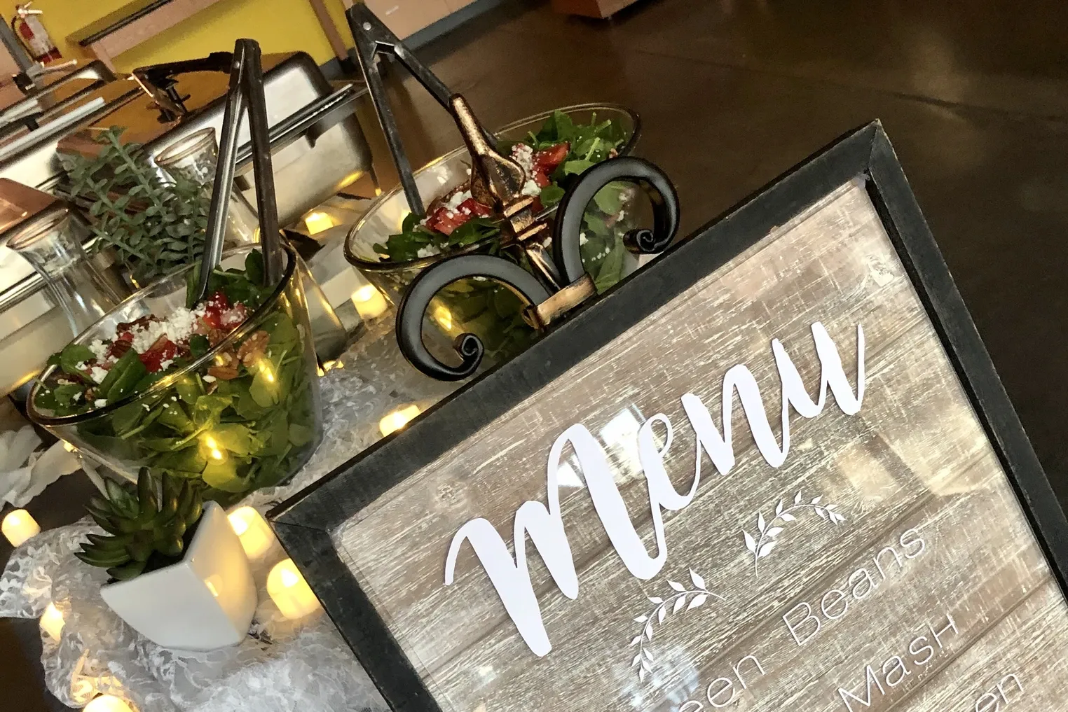 Salad station with a hand lettered menu sign and succulents