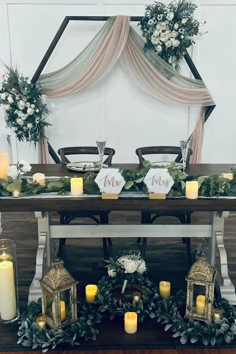 Hexagon arch draped in blush behind a sweetheart table