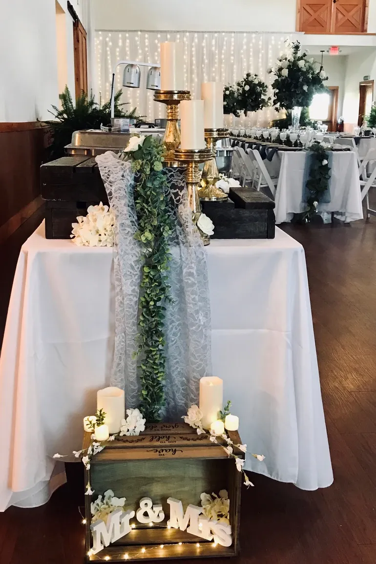 Buffet table with a lace runner, candles, and brass stands