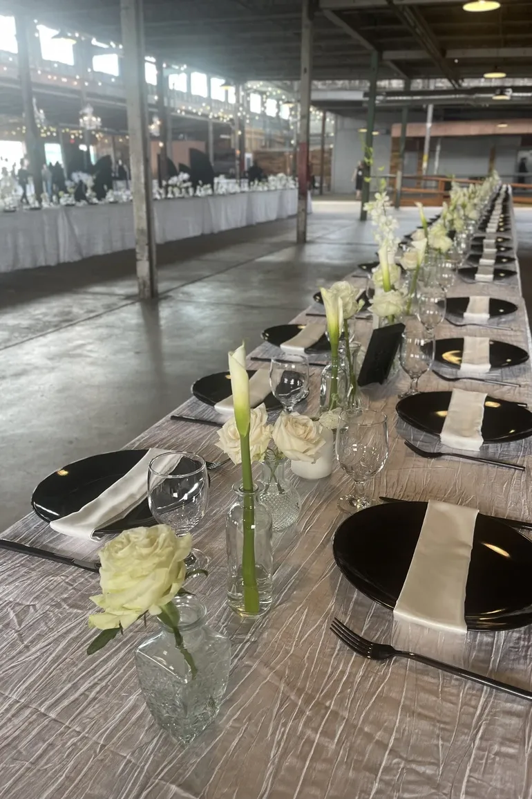 Industrial hall with long white tables and calla lilies