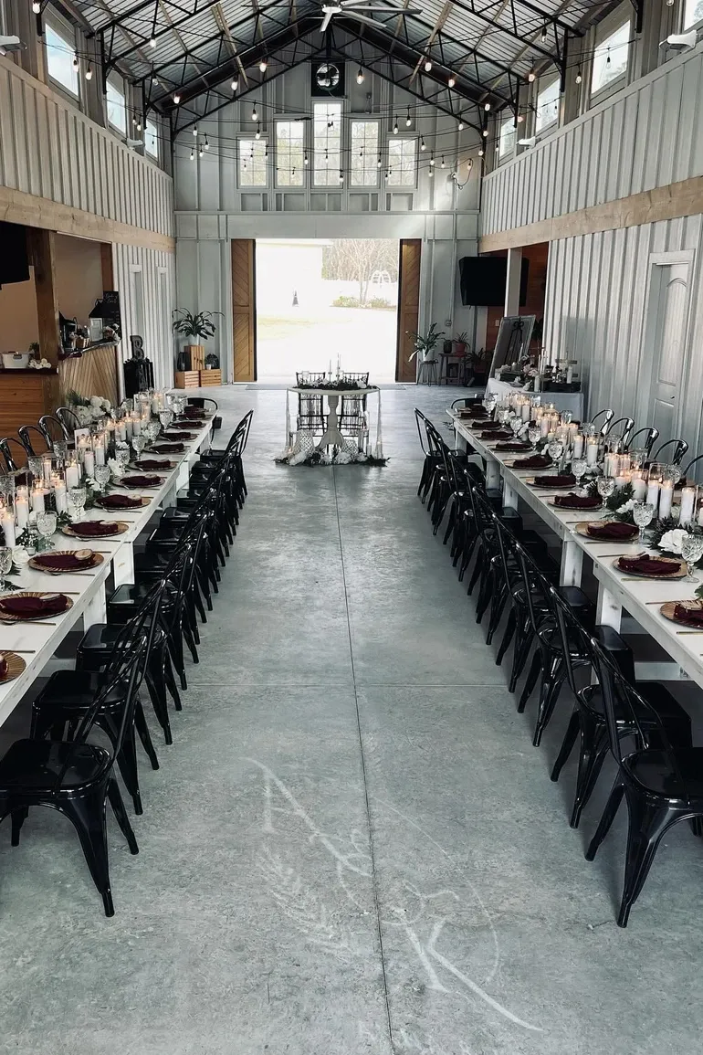 Long white reception tables leading to open barn doors.