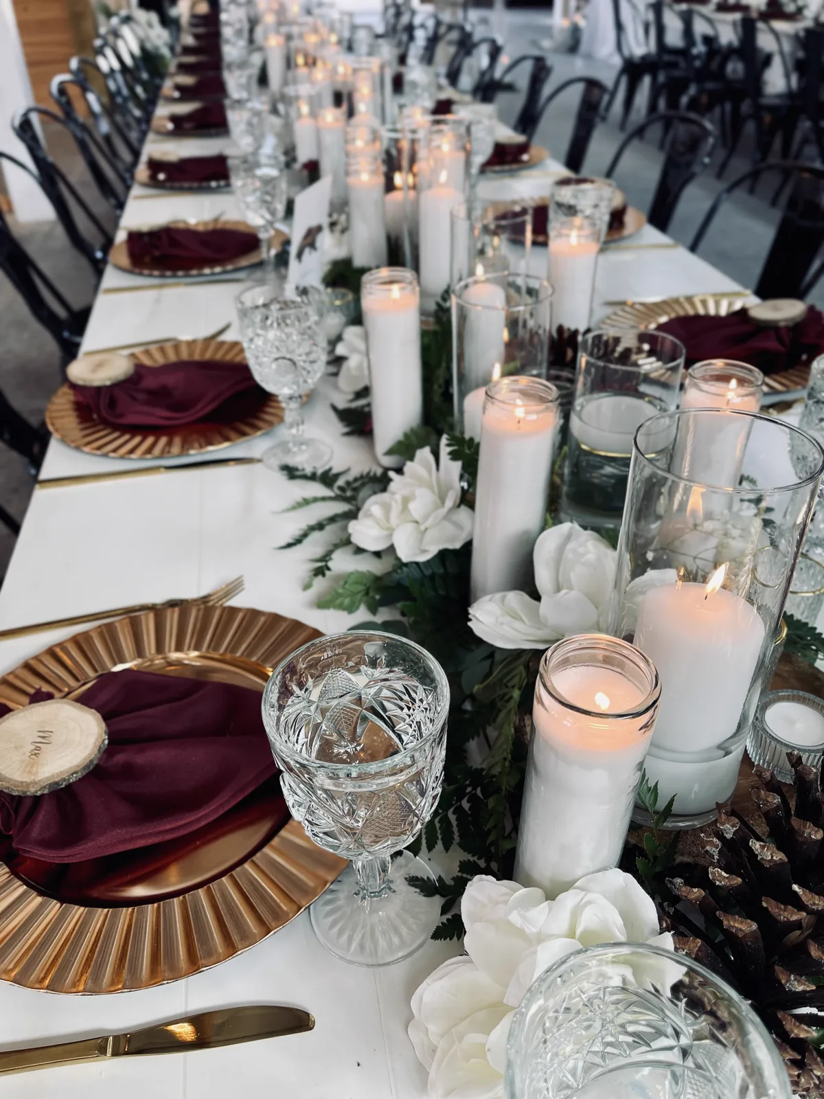 A long reception table lined with candles and gold chargers