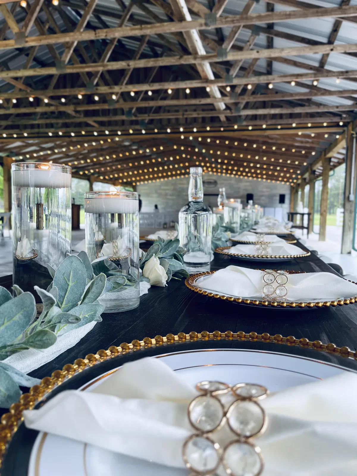 Reception tables set under a pergola strung with lights