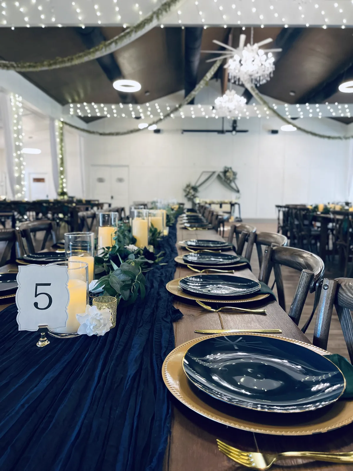 A navy and gold table setting with a table number card
